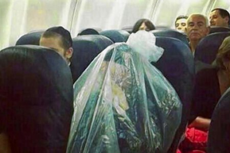 شخص يغلف نفسة في كيس عند السفر في الطائرة